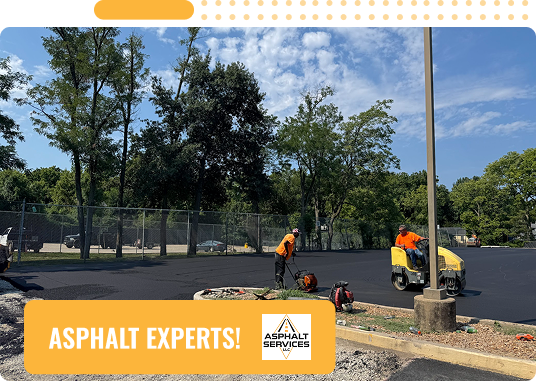 Two workers in orange shirts pave a parking lot with fresh asphalt using construction equipment on a sunny day in St. Louis, MO. Trees and a fence border the scene, with an Asphalt Services logo and a sign reading ASPHALT EXPERTS! Concrete Services offered.
